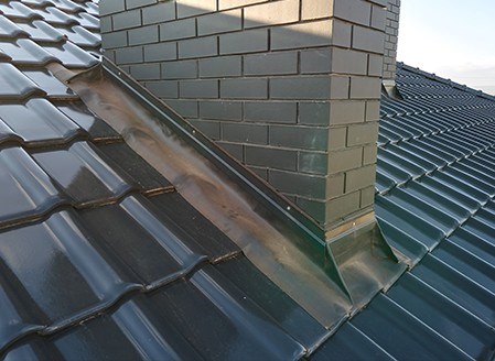checking flashing during a roof inspection in deerfield