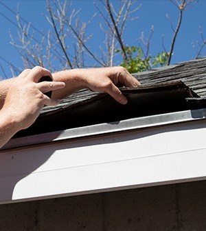 checking roof shingles during a roof inspection in deerfield